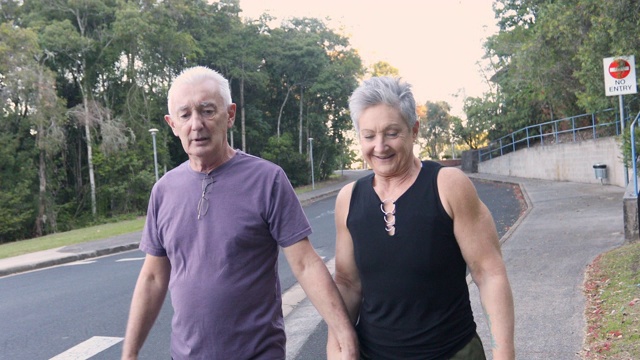 一对积极健康的老年夫妇在安静的街道上散步视频下载