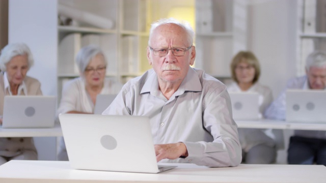 严肃的老人在电脑课上摆姿势视频素材