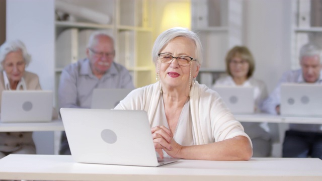 迷人的老太太在电脑课上使用笔记本电脑视频素材