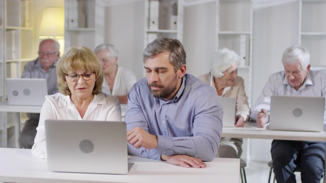 教师帮助老年妇女学习电脑技能视频素材