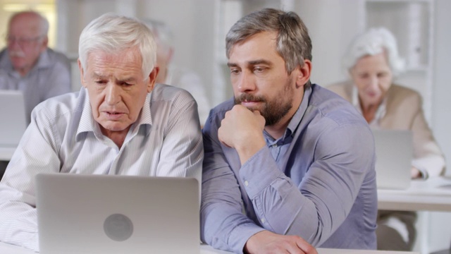 男人教老人如何使用笔记本电脑视频素材