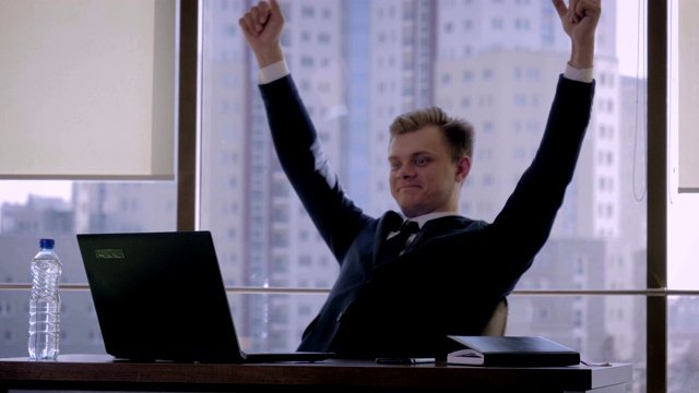 成功的商人在办公室举起双手表示胜利视频素材