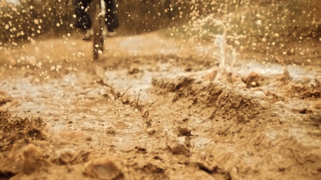 超级慢动作:山地摩托车手在泥浆中超速行驶视频素材