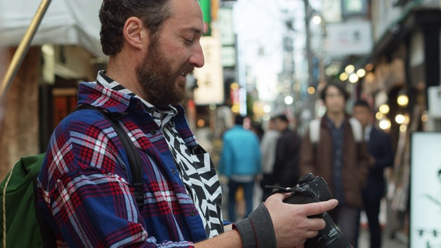 在日本看相机的白人游客视频素材