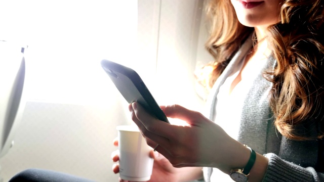 一名年轻女子在飞机上玩智能手机视频素材