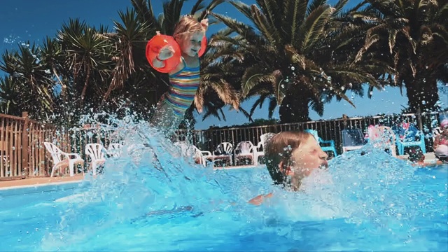 兄弟姐妹在度假村的游泳池里跳视频素材