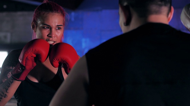 一个女拳击手在拳击圈内拳击的特写。女子拳击训练。运动——指导视频素材