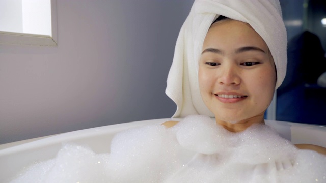 4K镜头特写女人在浴缸里洗澡玩泡泡。视频下载