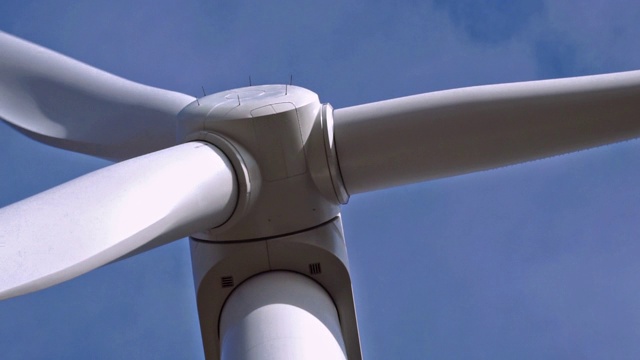 特写的风力涡轮机转子叶片旋转的蓝天背景视频素材