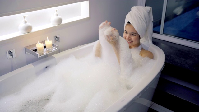 4K镜头特写女人在浴缸里洗澡玩泡泡。视频素材