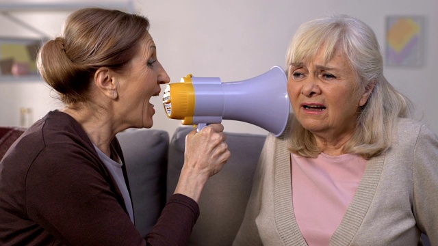 老妇人通过扩音器大喊给朋友，听力损失的疾病，问题视频下载