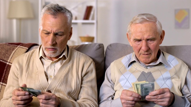 可怜的退休男子数着钱看着摄像机，退休年龄增加了视频下载