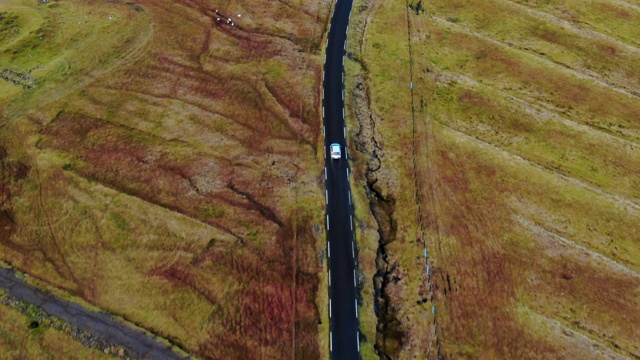 空中汽车在风路上行驶，穿过绿草地，斯特雷莫伊岛，法罗群岛视频下载