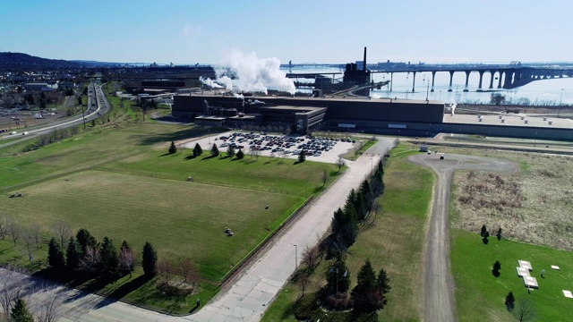 工业是否意味着污染?该工厂位于明尼苏达州五大湖之一的苏必利尔湖岸边。无人机视频与电影摄像机复杂的全景和轨道运动。视频下载