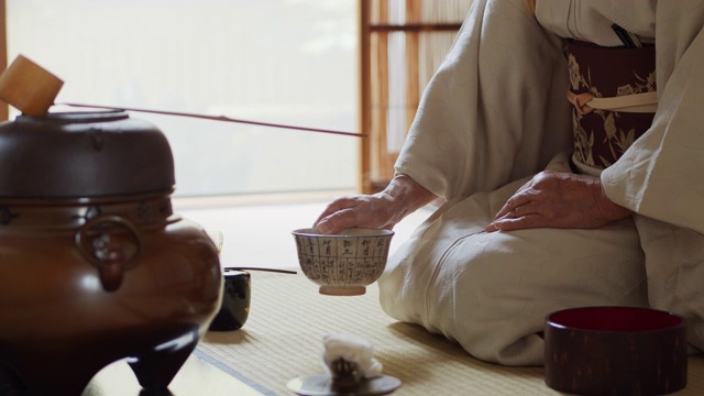 在日本传统茶道上，主人搅拌茶并奉上碗视频素材