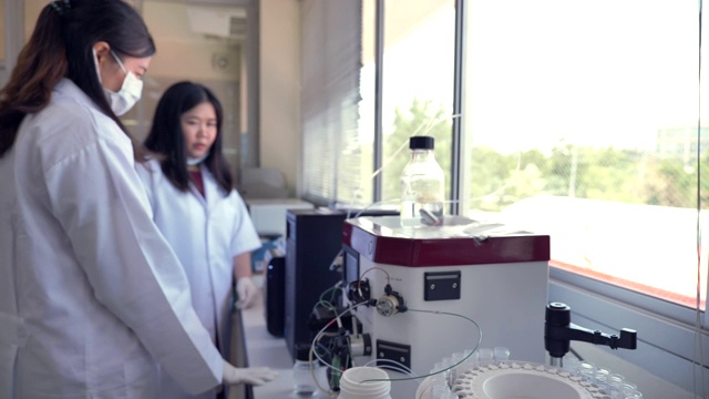 场景慢镜头两位科学家在实验室使用蛋白质纯化，概念科学和技术在实验室，科学家在实验室工作视频素材