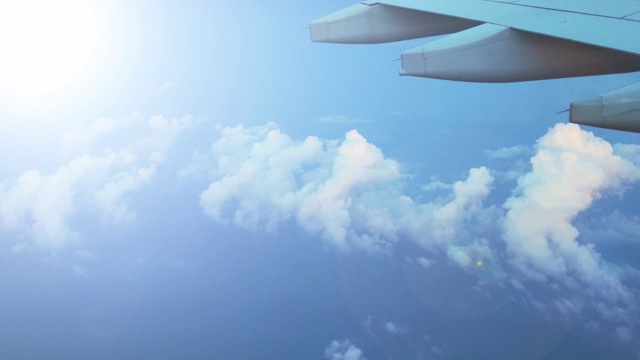 从飞机窗口鸟瞰。机翼飞机和美丽的白云在蓝天视频素材