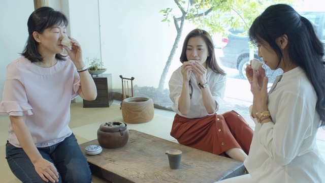 三个中国妇女坐在榻榻米上喝茶视频素材