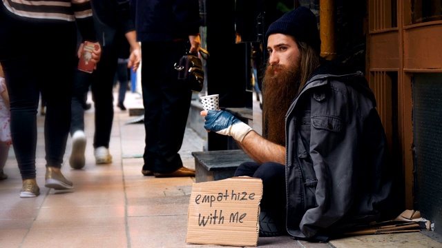 无家可归的人拿着“同情我”纸板，在拥挤的街道上乞讨视频下载