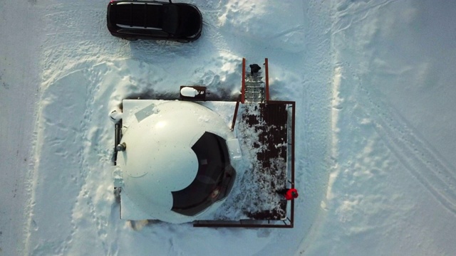 空中爬升:阿拉斯加费尔班克斯雪原上带汽车的冰屋屋视频素材