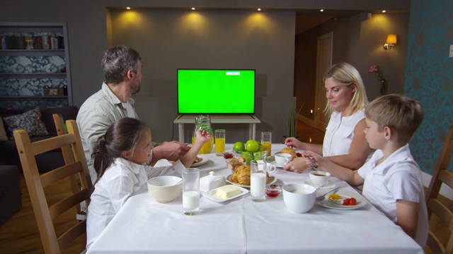 家庭吃早餐和看电视与色度键屏幕视频素材