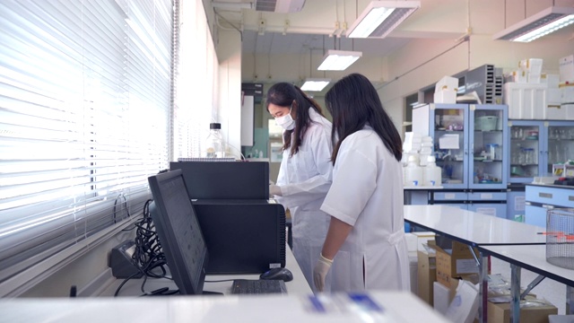 场景慢镜头两位科学家在实验室使用蛋白质纯化，概念科学和技术在实验室，科学家在实验室工作视频素材
