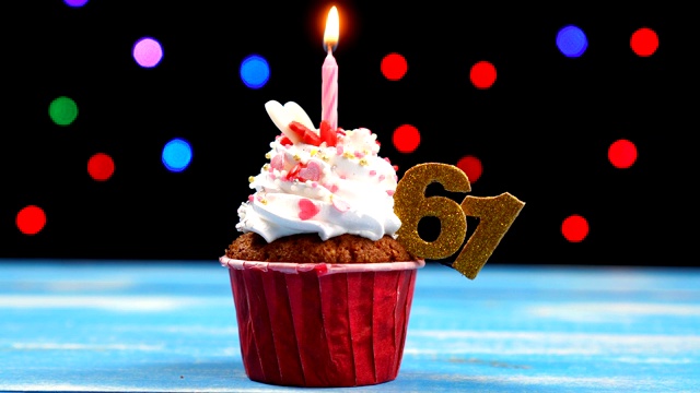美味的生日蛋糕与燃烧的蜡烛和数字61在彩色模糊的灯光背景视频素材