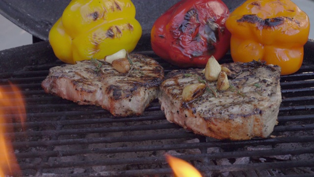 生酮烤带骨猪排的视频，完全煮熟的彩色烤辣椒，与火烧烤视频素材
