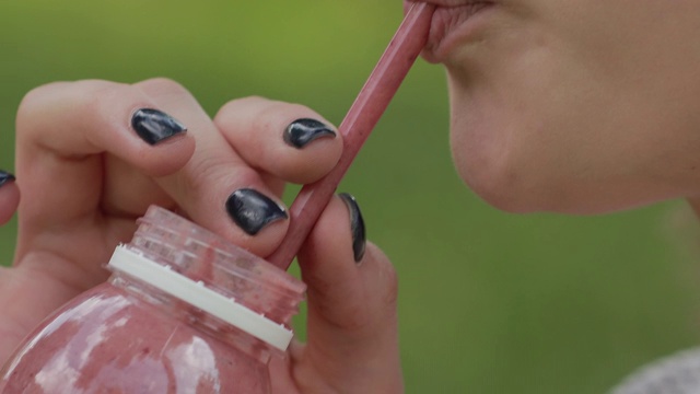 年轻女子喝新鲜冰沙通过吸管，宏视频视频素材