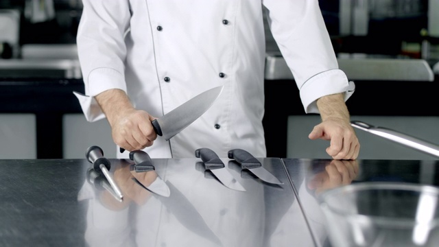 厨师选择刀在厨房做饭。特写男子准备做饭的双手。视频素材