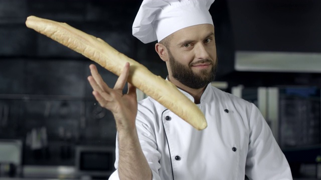 厨师在厨房里用法式面包开玩笑。特写男子的手玩面包。视频素材