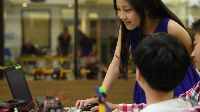 团队合作!一群孩子在学校一起编写机器人程序视频素材