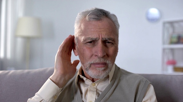 困惑的老人试图听到谈话，老年耳聋的问题视频素材
