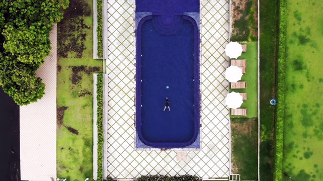 鸟瞰亚洲妇女游泳在游泳池视频素材