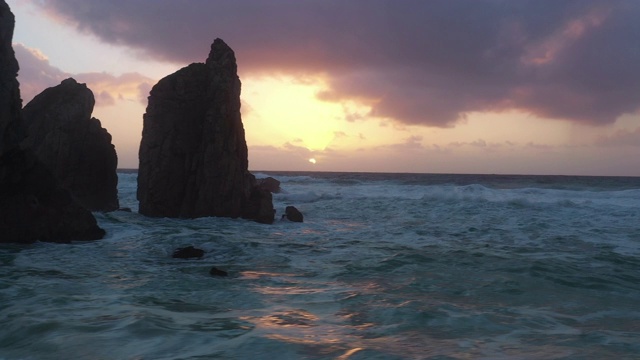 无人机拍摄的日落时分，里斯本附近的海滩上的天然石柱视频素材