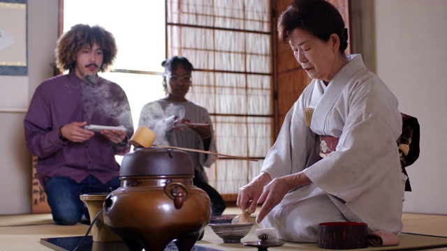 日本茶艺大师为两名游客泡茶视频素材