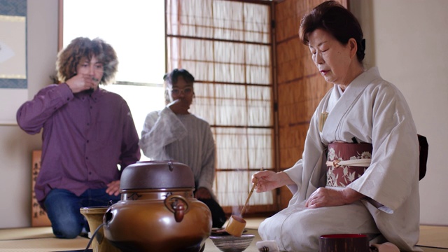 日本茶艺大师为两名游客泡茶视频素材