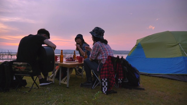 暑期一群亚洲青少年在湖边野餐，欣赏大自然的慢镜头。他们是快乐的，有乐趣的假期，放松的时刻。青少年自然户外日常生活的概念视频下载