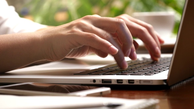 这是女性手指在笔记本电脑上按按钮和打字的滑动照片。在家在线工作的女人。UHD视频素材