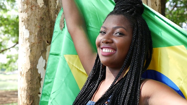 一名巴西年轻女子在公园里举着国旗视频下载