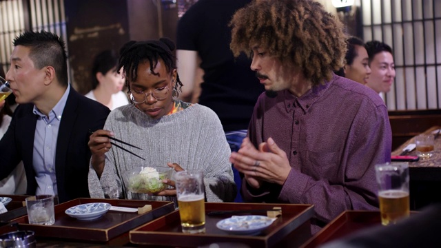 一对年轻的游客夫妇在日本居酒屋放松视频素材