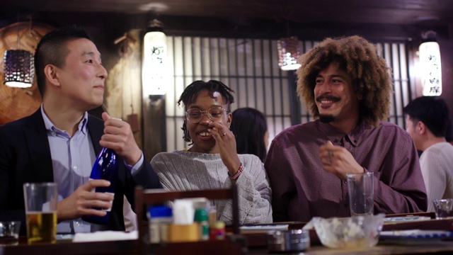 在日本传统的居酒屋，游客与当地人一起喝清酒视频下载