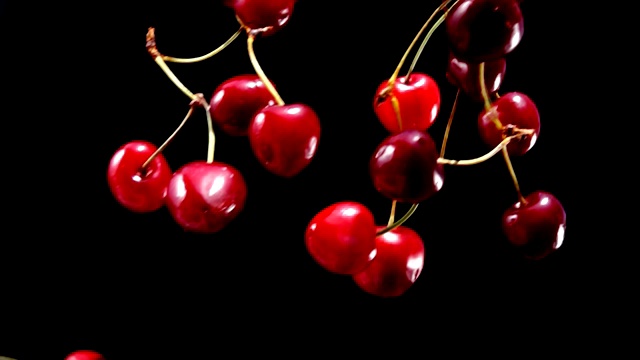 成熟的樱桃滴在黑色的背景上视频素材