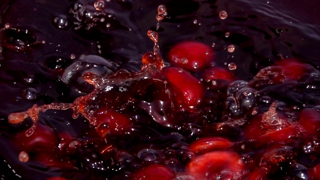 熟透的樱桃浆果一半落入果汁中视频素材