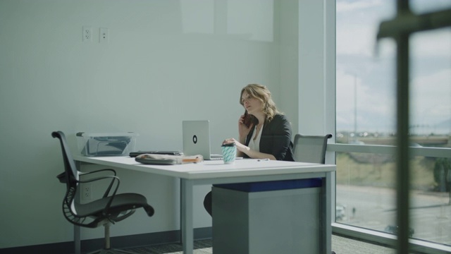 放大图片，在美国犹他州Pleasant Grove的办公室里，一位女商人正在用手提电脑打电话视频素材