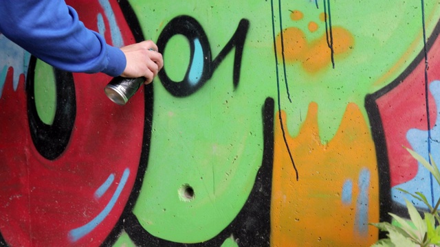 年轻的成年涂鸦艺术家在乡村的隧道里作画视频素材