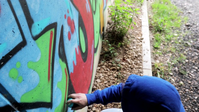 年轻的成年涂鸦艺术家在隧道里作画视频素材