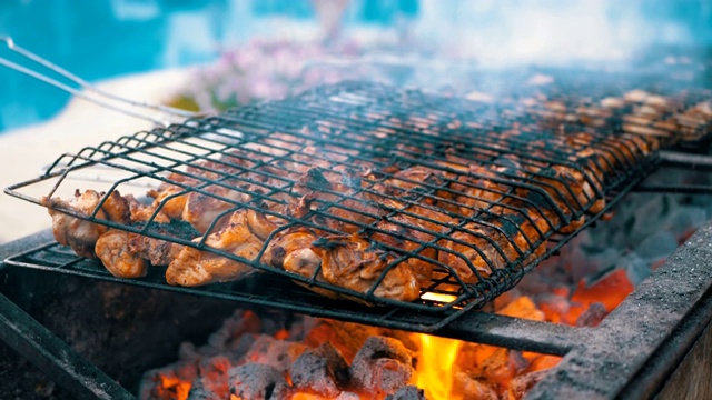 鸡肉烧烤是在一个大型烧烤由厨师在酒店的游泳池与蓝色的水。埃及视频下载