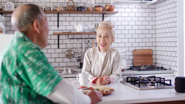中景:一对老年夫妇在厨房里一起放松视频素材