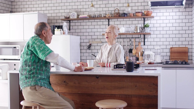 中景:一对老年夫妇在厨房里一起放松视频素材